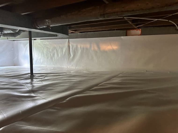 Fully encapsulated crawlspace with a white vapor barrier sealed across the floor and foundation walls.