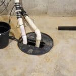 Thumbnail image of Basement sump pump basin with discharge piping installed to collect groundwater and pump it safely away from the foundation, helping keep the basement dry and protected from water intrusion.