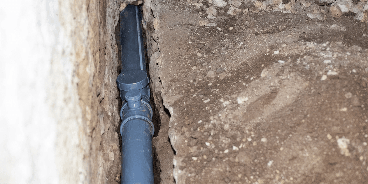 Interior foundation drainage pipe installed in a trench along the perimeter of a basement wall as part of a waterproofing system to collect and redirect groundwater before it enters the living space.
