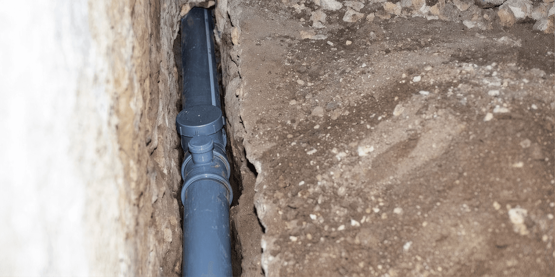 Drainage pipe installed in a trench along a foundation wall to help redirect water away from the structure.