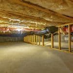 Thumbnail image of Crawl space with fiberglass insulation installed between floor joists, exposed ductwork, wooden support framing, and a clean concrete floor, providing improved energy efficiency, thermal protection, and under-home insulation.