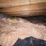 Thumbnail image of Crawlspace with sagging, displaced fiberglass insulation and exposed floor joists, highlighting the need for insulation replacement and moisture control.