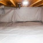 Thumbnail image of Clean, fully encapsulated crawlspace with a white vapor barrier covering the floor and walls to protect against moisture and improve air quality.